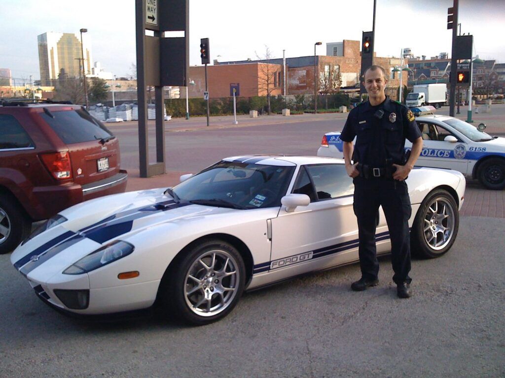 Jared in Dallas Police uniform with a Ford GT